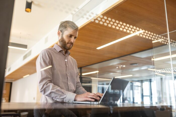 A man types on a laptop